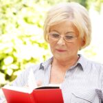 Senior woman reading on summer day outside